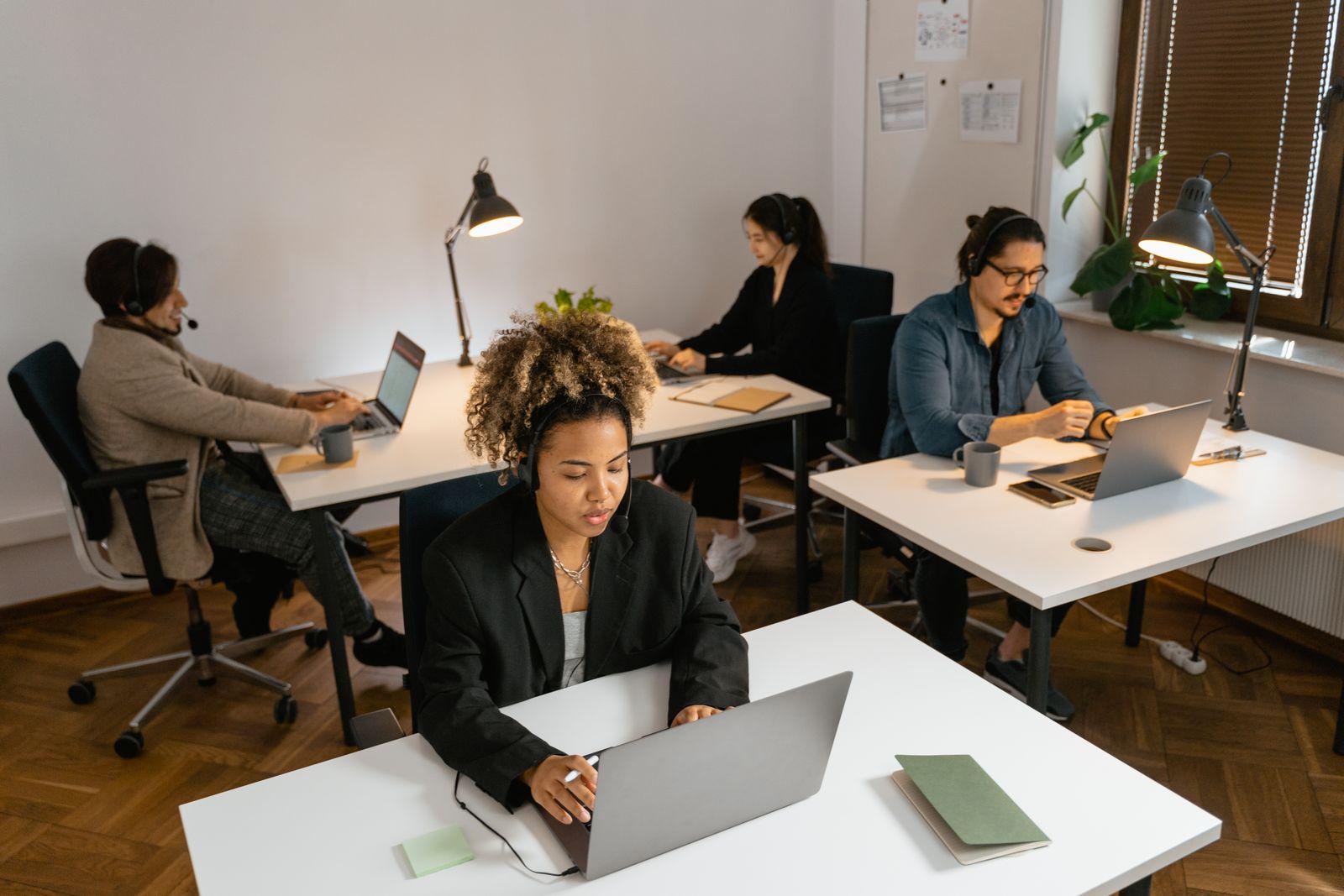 A customer service team working at computers in a modern support office