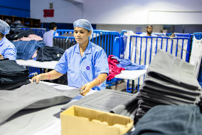 Garment factory worker inspecting fabric on the production floor